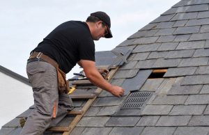 Roofer repairing a roof with shingle damage